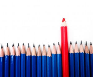 blaze your own trail - one red pencil standing above a group of blue pencils